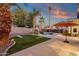 Lush backyard oasis showcasing palm trees, refreshing pool, and outdoor lounge with a vibrant bean bag toss at 14823 S 13Th Pl, Phoenix, AZ 85048