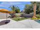 Spacious backyard featuring an expansive patio area, artificial turf, mature landscaping, and an umbrella for shade at 14823 S 13Th Pl, Phoenix, AZ 85048