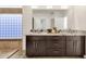 Elegant bathroom featuring a double sink vanity with granite countertops, wood cabinets and a framed mirror at 14823 S 13Th Pl, Phoenix, AZ 85048