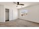 Bright bedroom includes neutral carpet, a ceiling fan, and a window overlooking the neighborhood at 14823 S 13Th Pl, Phoenix, AZ 85048