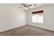 Bright bedroom features neutral carpet, a ceiling fan, and a window with wooden shades at 14823 S 13Th Pl, Phoenix, AZ 85048