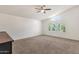 Bright bedroom features neutral carpet, a ceiling fan, and a window overlooking greenery at 14823 S 13Th Pl, Phoenix, AZ 85048