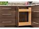 View of kitchen cabinet features a wooden pull-out organizer for maximized space at 14823 S 13Th Pl, Phoenix, AZ 85048