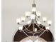 A contemporary chandelier with frosted glass shades casts a warm glow in the room at 14823 S 13Th Pl, Phoenix, AZ 85048