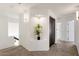 Bright hallway with recessed niche and storage cabinets with black pulls at the end of the hall at 14823 S 13Th Pl, Phoenix, AZ 85048