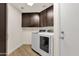 Efficient laundry room featuring a modern washer and dryer set with dark wood cabinetry at 14823 S 13Th Pl, Phoenix, AZ 85048