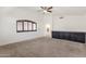 Bright living room boasts neutral carpet, ceiling fan, built-in cabinets, and an arched window with plantation shutters at 14823 S 13Th Pl, Phoenix, AZ 85048