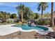Inviting pool area with rock waterfall feature, mature palms, and well-manicured landscaping provides a backyard oasis at 14823 S 13Th Pl, Phoenix, AZ 85048