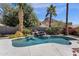 Inviting pool area with rock waterfall feature surrounded by lush landscaping, mature palms, and ample space for relaxation at 14823 S 13Th Pl, Phoenix, AZ 85048