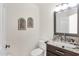 Elegant half bathroom with granite countertop, framed art, and modern fixtures at 14823 S 13Th Pl, Phoenix, AZ 85048