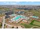 Aerial view of the community pools with palm trees, lounge chairs, and lush landscaping in a Primary planned community at 17332 W Wildwood St, Surprise, AZ 85388