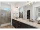 Elegant bathroom boasting double sinks, granite countertops, and a glass-enclosed shower at 17332 W Wildwood St, Surprise, AZ 85388