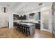 Modern kitchen featuring a large island with seating, pendant lighting, and dark cabinetry at 17332 W Wildwood St, Surprise, AZ 85388