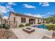 The backyard shows a pool, fire pit, travertine deck, artificial grass and desert landscaping at 19571 E Strawberry Dr, Queen Creek, AZ 85142
