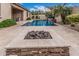 Inviting backyard with a pool, water feature, travertine deck, fire pit, and low maintenance landscape at 19571 E Strawberry Dr, Queen Creek, AZ 85142