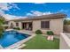 Resort-style backyard with pool, covered patio, cornhole boards, and lush landscaping at 19571 E Strawberry Dr, Queen Creek, AZ 85142