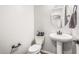Clean powder room with a pedestal sink, toilet, and tasteful decorations at 19571 E Strawberry Dr, Queen Creek, AZ 85142
