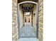 Wrought iron security gate offers a glimpse of the home's entry, framed by elegant stone pillars at 19571 E Strawberry Dr, Queen Creek, AZ 85142