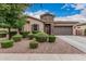 Charming single-story home featuring manicured landscaping, a stone entrance, and a two-car garage at 19571 E Strawberry Dr, Queen Creek, AZ 85142