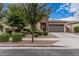 Inviting single-story home with mature trees, meticulously trimmed bushes and a two-car garage at 19571 E Strawberry Dr, Queen Creek, AZ 85142