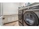 Well-organized laundry room features tile flooring, neutral paint, modern washer/dryer, and storage shelving at 19571 E Strawberry Dr, Queen Creek, AZ 85142
