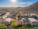 A sunny aerial view of the home in a desert community, with mountain views and other homes at 23005 N 19Th Way, Phoenix, AZ 85024