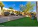 Landscaped backyard with lush green artificial grass, playset, and desert flora at 23005 N 19Th Way, Phoenix, AZ 85024