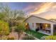 Spacious backyard boasts artificial grass, a playset, string lights, covered patio, and desert landscape at 23005 N 19Th Way, Phoenix, AZ 85024