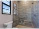 Modern bathroom with a glass walk-in shower featuring stone-look tile and a window at 23656 N 123Rd St # 240, Scottsdale, AZ 85255