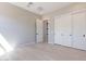 Neutral bedroom with light hardwood flooring and sliding door closet and a peek into another room at 23656 N 123Rd St # 240, Scottsdale, AZ 85255