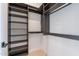 Walk-in closet with built-in dark wood shelving and light wood floors at 23656 N 123Rd St # 240, Scottsdale, AZ 85255