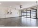 Spacious garage with epoxy flooring, contemporary door, and water heaters on the back wall at 23656 N 123Rd St # 240, Scottsdale, AZ 85255