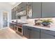 A modern kitchen features dark gray cabinetry, marble countertops, stainless steel appliances, and under-cabinet lighting at 23656 N 123Rd St # 240, Scottsdale, AZ 85255