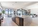 A luxury kitchen with gray island overlooks an open living and dining area featuring mountain views from walls of windows at 23656 N 123Rd St # 240, Scottsdale, AZ 85255