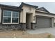 Charming one-story home with stone accents, a gray two-car garage door, and a well-kept front yard at 23972 W Cocopah St, Buckeye, AZ 85326