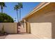 Gated backyard featuring desert landscaping and palm trees at 25850 S Foxglenn Dr, Sun Lakes, AZ 85248