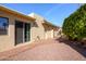 Beige home exterior with brick pathway, gravel landscaping, mature green shrubbery, and decorative metal entry gate at 25850 S Foxglenn Dr, Sun Lakes, AZ 85248