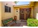 Inviting entryway featuring double doors adorned with wreaths, a bench, and potted plants enhancing the home's curb appeal at 25850 S Foxglenn Dr, Sun Lakes, AZ 85248