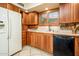 Kitchen featuring wood cabinets, white countertops, and stainless steel appliances, window with custom blinds at 25850 S Foxglenn Dr, Sun Lakes, AZ 85248