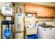 Functional laundry room with utility sink, water heater, washer, dryer, and storage cabinets at 25850 S Foxglenn Dr, Sun Lakes, AZ 85248