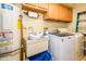 Functional laundry room with a utility sink, washer, dryer, and storage cabinets, catering to everyday needs at 25850 S Foxglenn Dr, Sun Lakes, AZ 85248