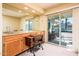 Wet bar with wooden cabinets, a built in sink, mirror backsplash, and sliding glass doors leading to the outside patio at 25850 S Foxglenn Dr, Sun Lakes, AZ 85248