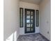 Stylish front entrance featuring a modern black door with glass panels and a stone-paved porch at 2606 E Virginia Cir, Mesa, AZ 85213