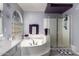 Luxurious bathroom with a soaking tub, glass-enclosed shower, and stylish chandelier at 26066 N 72Nd Ave, Peoria, AZ 85383