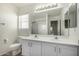 Bathroom with double sink vanity, large mirror, and a tub with shower at 26066 N 72Nd Ave, Peoria, AZ 85383