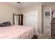 Cozy bedroom featuring closet, mirror, and a comfortable bed with a pink blanket at 26066 N 72Nd Ave, Peoria, AZ 85383