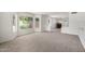 Bright living room with neutral carpet, ample natural light, and open layout at 26066 N 72Nd Ave, Peoria, AZ 85383
