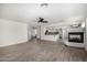 Open-concept living area with wood-look tile, fireplace, and an adjoining kitchen at 26066 N 72Nd Ave, Peoria, AZ 85383