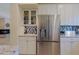 Kitchen features stainless steel refrigerator, white cabinets and mosaic backsplash at 32835 N 70Th St, Scottsdale, AZ 85266
