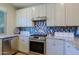 Kitchen features white cabinets, mosaic backsplash and stainless steel appliances at 32835 N 70Th St, Scottsdale, AZ 85266